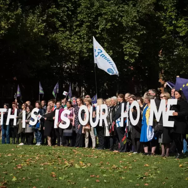 Group of people holding letters spelling &quot;This is our home&quot;